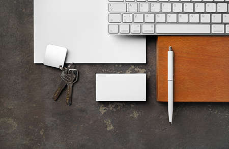 Blank real estate agency stationery set. Blank business card, key, keyboard, pen and paper. flat lay.の写真素材