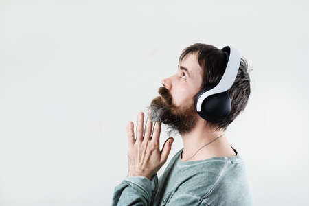 Bearded man wearing headphones listening to music. enjoy music. profile view.の写真素材