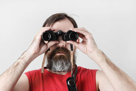 Man with binoculars. Bearded man looking through binocular.の写真素材