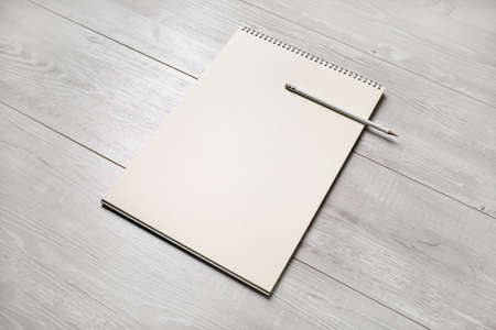 Photo of blank notepad and pencil on light wooden background. Blank objects for placing your design.の写真素材