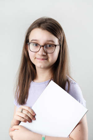 Smiling girl wearing glasses with blank sketchbook. education concept.の写真素材