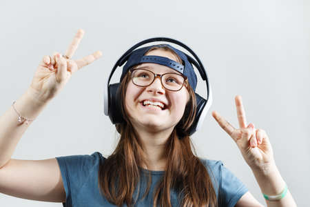 Laughing teen girl listening to music in headphones. Child girl enjoying music.の写真素材