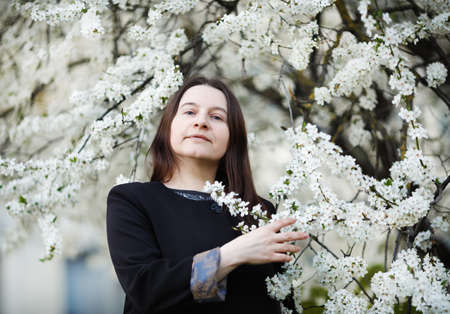 Woman in the park on the background of flowering spring tree. selective focus.の写真素材