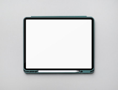 Photo of modern touch tablet with blank white screen and stylus on gray paper background. Modern work tools of designer. flat lay.の写真素材