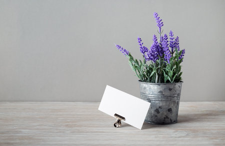 Blank white business card and tin bucket with artificial lavender. Copy space for your text.の写真素材