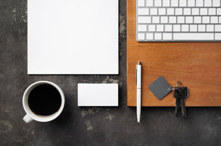 Real estate concept. Blank business card, coffee cup, key, keyboard, pen and paper. Flat lay.の写真素材
