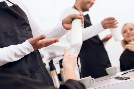 Female stylist show thumbs up to mature woman. Hairdresser recommend hair shampoo for woman. Mature pretty woman is doing hairdo in beauty salon.の写真素材