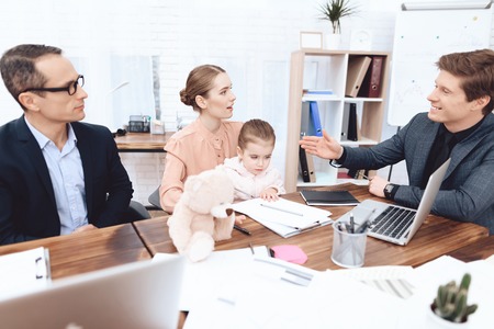 Men have a complaint about a woman who came with her daughter to work. This is a business office.の写真素材