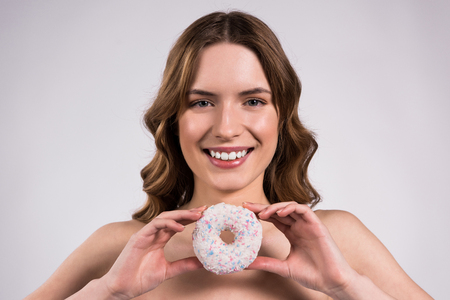 Girl is posing with glazed gonut isolated on white background.の写真素材