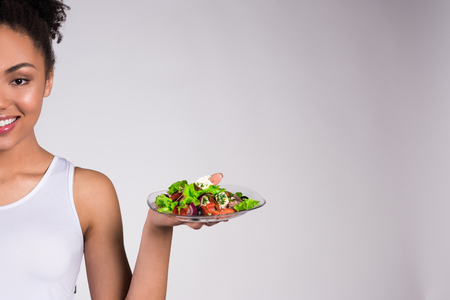 African American girl holding salad isolated on white background.の写真素材