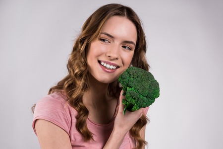 Happy girl posing with broccoli isolated on white background.の写真素材
