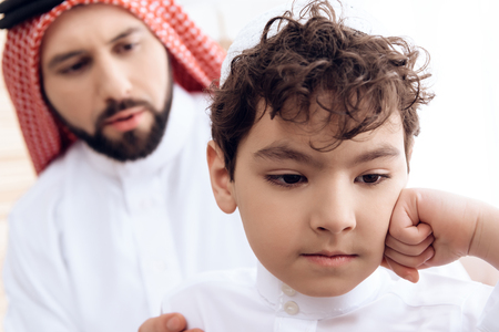 Close up. Arab man asks for forgiveness from small offended son. Relationship between father and son.の写真素材