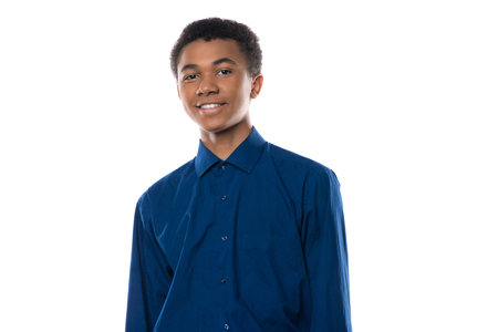 Portrait of cheerful african american teenager in denim shirt. Isolated on white background.の写真素材