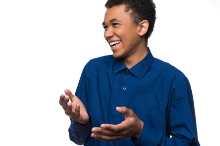 Portrait of cheerful african american teenager in denim shirt. Isolated on white background.の写真素材
