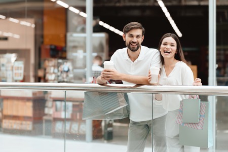 Man and woman with shopping bags in shopping mall. Couple is relaxing, happy after shopping.の写真素材