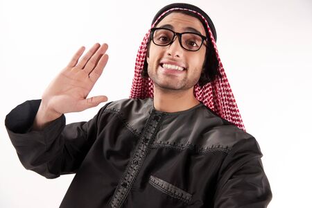 Arab man in keffiyeh makes self portrait with phone. Selfie. Isolated on white background.の写真素材