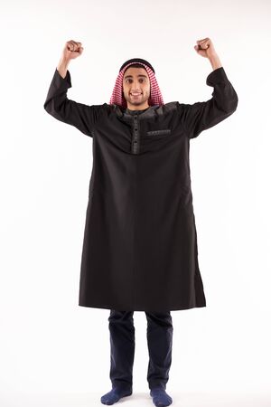 Arab man in keffiyeh stands with arms raised. Rebellion concept. Isolated on white background.の写真素材