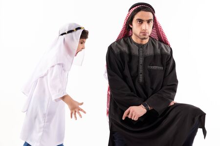 Arab boy screams at adult father in keffiyeh. Isolated on white background. Parenthood concept.の写真素材