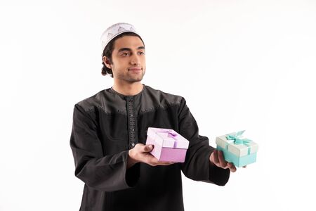 Arab man holds in hands two gift boxes. Isolated on white background. Studio portrait.の写真素材
