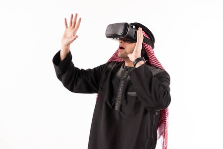 Arab man in virtual reality glasses plays interactive game. Future technology concept. Isolated on white background.の写真素材