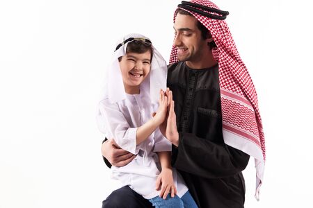 Arabian boy gives five fathers in keffiyeh. Parenthood concept. Isolated on white background.の写真素材