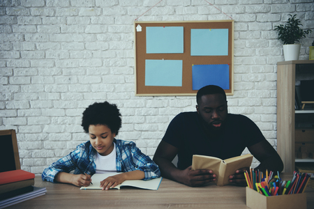 African American single father helps little son to do homework at home. Child education concept. Fatherhood.の写真素材