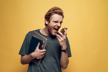 Portrait of Disappointed Angry Man Talks on Phone. Rude Aggressive Man Screaming Bossy while talking...
