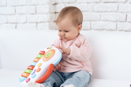 Smiling newborn baby on sofa playing toy. Newborn concept.の写真素材
