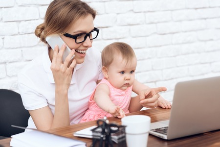 Young business lady try to work with cute baby. Business, motherhood concept.の写真素材