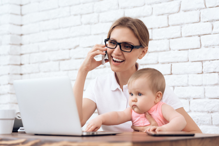 Young business lady try to work with little baby. Business, motherhood concept.の写真素材