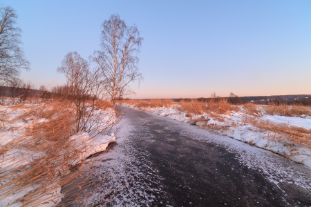 In the cold morning the frozen small river on sunriseの写真素材