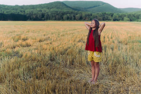 Side view portrait of happy beautiful girl breathing fresh air in field, outdoorsの写真素材