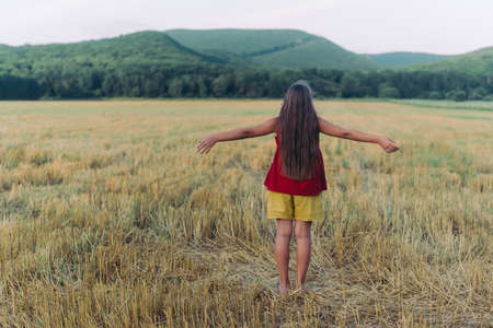 Side view portrait of happy beautiful girl breathing fresh air in field, outdoorsの写真素材