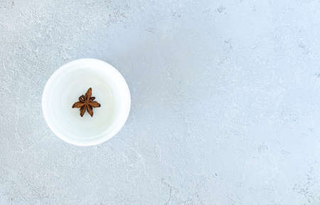 Anise on a white plate, on a gray backgroundの写真素材