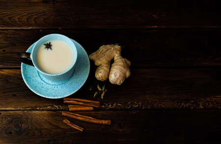 Indian masala chai tea. Masala chai spiced tea with milk and spices on dark rusty background.の写真素材
