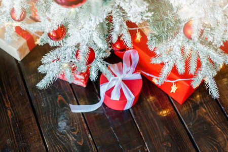Christmas gift boxes under the tree, on the wooden floor.の写真素材