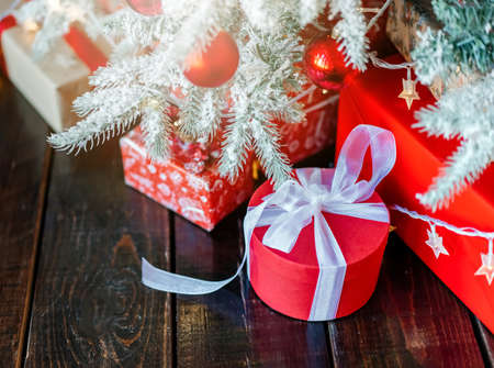 Christmas gift boxes under the tree, on the wooden floor.の写真素材