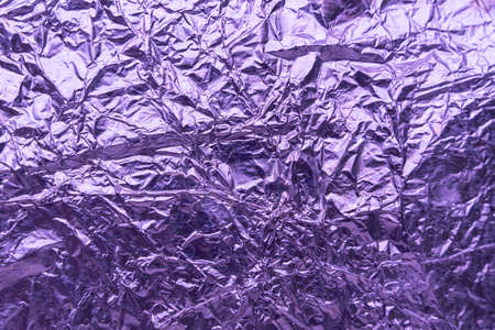 Crumpled very peri or violet foil background. abstract pattern. Trendy color of the Year 2022. High...