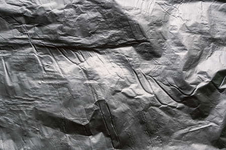 Crumpled and shiny silver paper background. high quality photoの写真素材