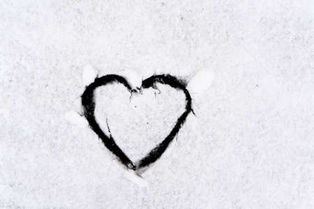 Heart symbol on snowy car glass with frash winter snow. high quality photoの写真素材