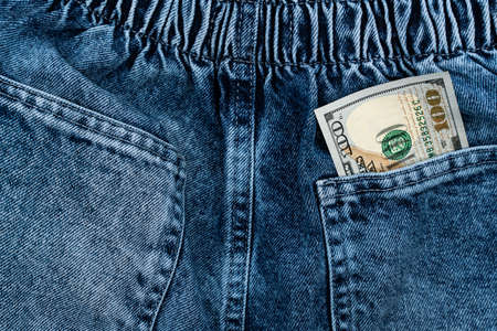 One hundred dollar bills in the back pocket of jeans. money in pocket concept. cash. high quality photoの写真素材