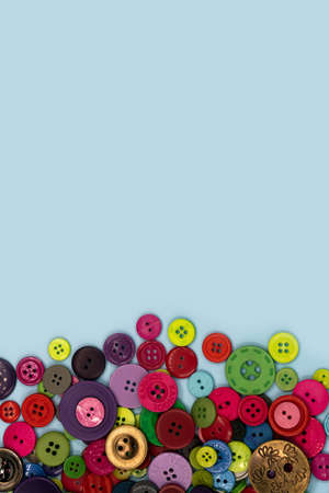 Colored sewing buttons composition on green pastel background. Flat lay with copy space.の写真素材