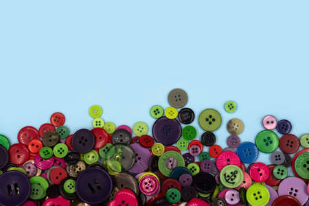 Colored sewing buttons composition on green pastel background. Flat lay with copy space.の写真素材