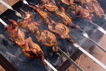 Preparation of marinated quail on the grill grate. high quality photoの写真素材