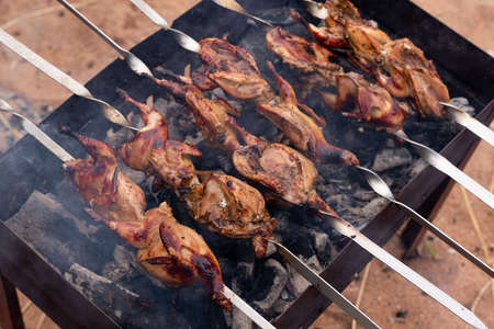 Preparation of marinated quail on the grill grate. high quality photoの写真素材