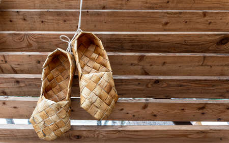 Birchen woven bast shoes hang on a log wall. high quality photoの写真素材