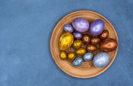 Easter background with golden and colored eggs. Happy easter background top view. high quality photoの写真素材