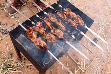 Preparation of marinated quail on the grill grate. high quality photoの写真素材