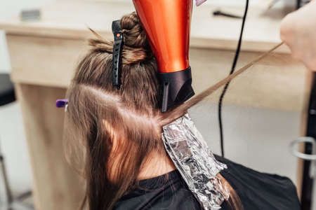 Professional hairdresser dying client's hair in beauty salon, closeup. high quality photoの写真素材