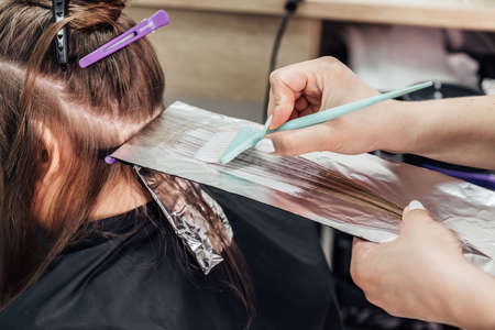Professional hairdresser dying client's hair in beauty salon, closeup. high quality photoの写真素材